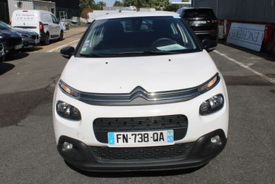 a small white car parked on the side of the road