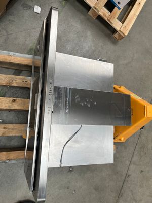 a picture of a table saw sitting on a pallet in a warehouse