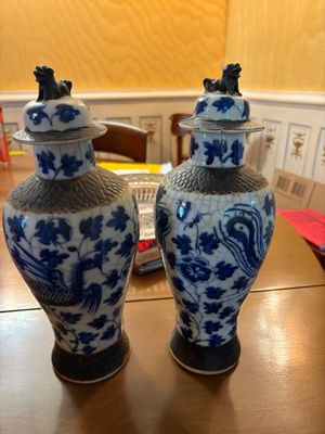 two blue and white vases sitting on a wooden table