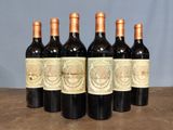 six bottles of wine are lined up on a wooden table