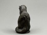 une petite statue représentant un ours assis par terre