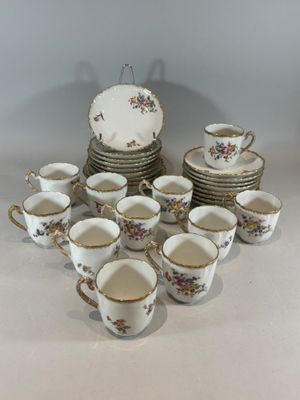 a lot of cups and saucers sitting on a table