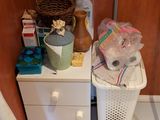 une armoire blanche surmontée d'un panier, à côté des toilettes