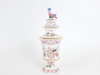 a white vase with a bird on top of it