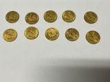 a bunch of gold coins sitting on top of a white table