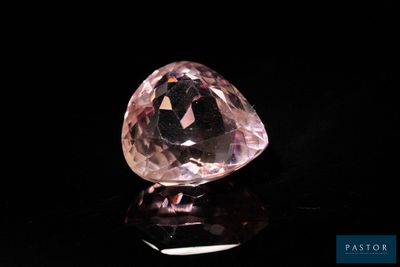 a close up of a pink diamond on a black surface
