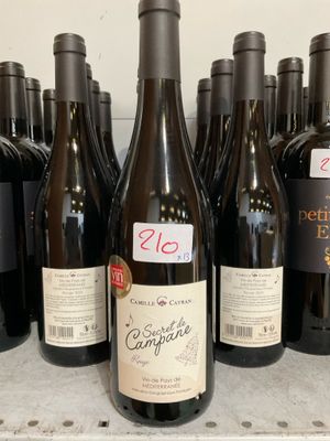 plusieurs bouteilles de vin sont alignées sur une étagère