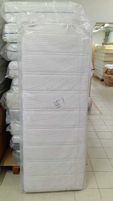 une grande pile de matelas posée sur une palette dans un entrepôt