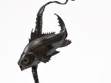 sculpture représentant un poisson posé sur un socle, avec un serpent sur le dos