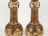 une paire de vases posés l'un à côté de l'autre sur une surface blanche