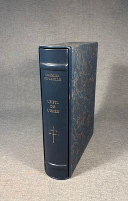 an old blue book with a cross on it sitting on a table