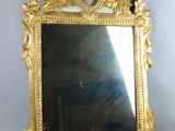 un miroir doré sur lequel est représentée une femme
