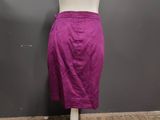 purple skirt on a mannequin stand in front of a gray wall