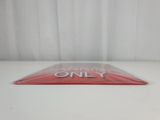 a close up of a sign on a table with a curtain in the background