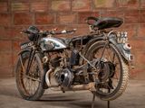 a old motorcycle that is parked in front of a brick wall