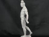 a white statue of a man holding a tennis racquet