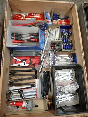 une boîte remplie d'outils posés sur le sol