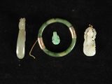 trois morceaux de jade et des bijoux en jade sur un fond noir