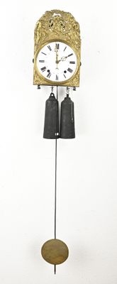 a clock that is hanging on the wall with bells