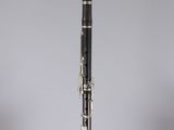 a close up of a black and gold clarinet on a clear stand