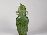 un vase en verre vert orné d'un oiseau et dont le couvercle est également décoré d'un oiseau
