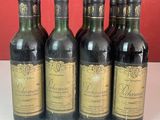 six bouteilles de vin sont alignées sur un comptoir