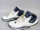 une paire de chaussures de basket blanches et bleues posées sur une surface blanche