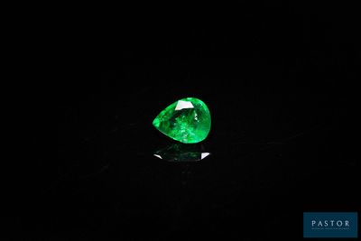 un gros plan sur une émeraude verte dans l'obscurité