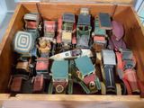 une boîte en bois remplie de vieilles petites voitures et de petits camions