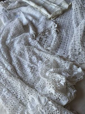une couverture blanche au crochet posée sur un lit, à côté d'un oreiller