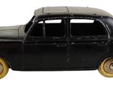 une petite voiture noire posée sur une surface blanche
