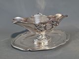 une assiette ancienne en argent, sur laquelle repose une soucoupe en argent