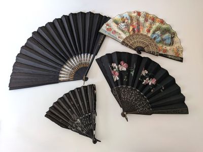 Quatre éventails chinois sont exposés sur une surface blanche