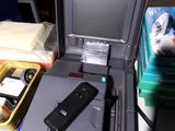 un ordinateur portable posé sur un bureau, à côté d'un téléphone portable