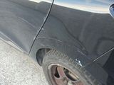 the rear end of a black car with a red tail light