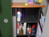 a cat that is sitting on the floor next to a shelf