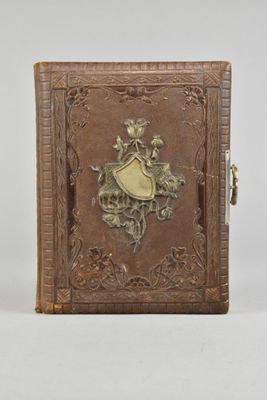 un vieux livre orné d'un motif décoratif, posé sur une surface blanche