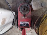 a red pipe cutter sitting on the ground next to other tools