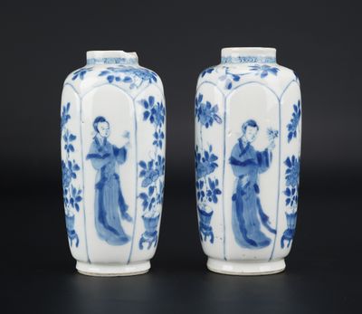 pair of blue and white vases with figures on them