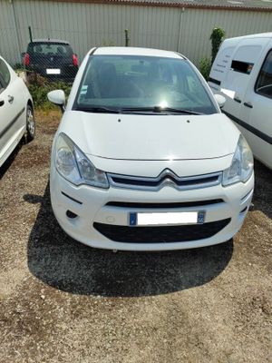 une petite voiture blanche garée sur un parking à côté d'une camionnette blanche