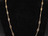 un collier plaqué or dont la chaîne a été placée sur un mannequin