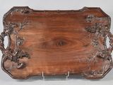 un plateau ancien en bois orné d'un motif sculpté