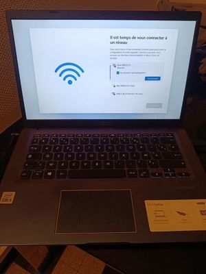 a laptop that is sitting on a table with a wifi sign on the screen
