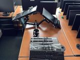 a desk with several computers and a keyboard on it