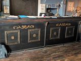 un bar noir et doré avec un sac à dos posé par terre