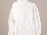 une photo d'une chemise blanche posée sur un présentoir pour mannequin