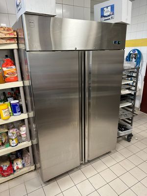 des réfrigérateurs en acier inoxydable dans un magasin où les rayons sont remplis de produits alimentaires