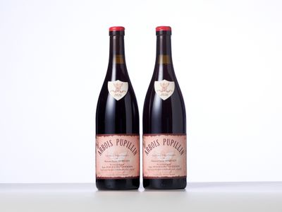 two bottles of red wine sitting on top of a table