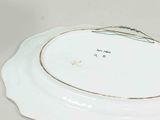 a white plate with a gold rim sitting on a table