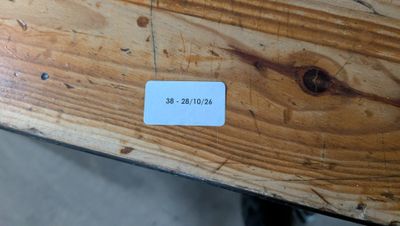 une étiquette collée sur un morceau de bois posé sur une table